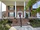 Charming brick home with a covered front porch, stately columns, and lush landscaping at 36 Forde Row, Charleston, SC 29412
