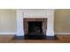 Close-up view of a traditional brick fireplace with a classic white mantel and black hearth at 36 Forde Row, Charleston, SC 29412