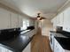 Charming kitchen featuring white cabinets, black countertops, and warm wood floors at 36 Forde Row, Charleston, SC 29412