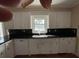 The bright kitchen is equipped with white cabinets, black countertops, and a stainless steel dishwasher at 36 Forde Row, Charleston, SC 29412