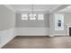 Dining room featuring hardwood floors, decorative wall molding, a modern chandelier, and three windows at 389 Wappoo Trace Ln, Summerville, SC 29486