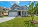 Two-story home featuring a gray exterior, well-maintained lawn, and a concrete driveway leading to an attached garage at 389 Wappoo Trace Ln, Summerville, SC 29486
