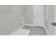 A laundry room with decorative floor tiles, washer hookups, door to outside, and storage shelf at 389 Wappoo Trace Ln, Summerville, SC 29486