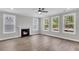 Bright living room featuring a fireplace, ceiling fan, and multiple large windows offering natural light at 389 Wappoo Trace Ln, Summerville, SC 29486