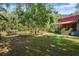 Expansive backyard featuring a pond, bridge, lush greenery and a charming log cabin-style home at 398 W Fisher Rd, Summerville, SC 29483