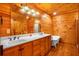 Bathroom with wood paneled walls, double sinks, a soaking tub, and wood floors at 398 W Fisher Rd, Summerville, SC 29483