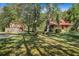 Secluded log home with a barn and a lush green yard with mature trees at 398 W Fisher Rd, Summerville, SC 29483