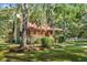 Charming log cabin with covered porch, landscaped yard, and mature trees at 398 W Fisher Rd, Summerville, SC 29483