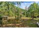 Picturesque pond reflecting trees, adjacent to a lush lawn and the home at 398 W Fisher Rd, Summerville, SC 29483