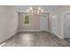 Bright dining area with gray floors, a modern chandelier, and plenty of natural light at 4013 B Ladson Rd, Ladson, SC 29456