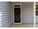 A black paneled front door with a glass upper panel, cream trim, and light gray siding at 4013 B Ladson Rd, Ladson, SC 29456