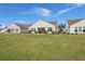 Expansive backyard with lush green lawn, showcasing the rear exteriors of well-maintained homes at 423 Four Seasons Blvd, Summerville, SC 29486