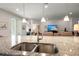 Close up on kitchen island with granite countertops, stainless steel sink, and pendant lights at 423 Four Seasons Blvd, Summerville, SC 29486
