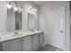 Bright bathroom features a double vanity, a gray cabinet, matching mirrors, lighting and a door at 431 Canal Crossing Way, Huger, SC 29450