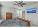 This bedroom offers natural light, a wooden sleigh bed, an entertainment area, and a ceiling fan at 431 Canal Crossing Way, Huger, SC 29450