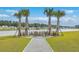 Fire pit is surrounded by Adirondack chairs and palm trees, overlooking the tranquil water at 431 Canal Crossing Way, Huger, SC 29450