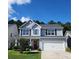 Charming two-story home with gray siding, a well-manicured lawn, and a welcoming red front door with a lovely wreath at 435 Foxbank Plantation Blvd Blvd, Moncks Corner, SC 29461