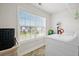Well-lit laundry room with a front-load washer, window, and patterned rug at 435 Foxbank Plantation Blvd Blvd, Moncks Corner, SC 29461