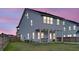 Exterior view showcasing the backyard of a two-story home with an under-deck patio at twilight at 435 Woodgate Way, Summerville, SC 29485