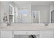 Modern bathroom with a shower and double vanity sinks with bright lighting seen in mirror at 435 Woodgate Way, Summerville, SC 29485