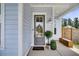 Charming front porch featuring classic columns and a beautiful front door, enhanced by lush landscaping at 435 Woodgate Way, Summerville, SC 29485