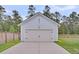 Detached garage with a white door and siding, surrounded by a well-maintained lawn and trees at 435 Woodgate Way, Summerville, SC 29485