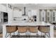 Bright, white kitchen with a large island, stainless steel appliances, and stylish woven counter stools at 435 Woodgate Way, Summerville, SC 29485
