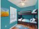 Turquoise bedroom with a bunk bed, wood floor, ceiling fan, blue rug and picture hanging on the wall at 4401 Prices Bridge Ln, Walterboro, SC 29488