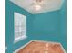 Turquoise bedroom with a wood floor, ceiling fan, window with blind, and electrical outlet at 4401 Prices Bridge Ln, Walterboro, SC 29488