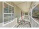 Covered porch with green rocking chair, red screen door, swing bench, white railing, and a window at 4401 Prices Bridge Ln, Walterboro, SC 29488