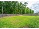 Grassy backyard with a wooden fence and mature trees at 5088 Thornton Dr, Summerville, SC 29485