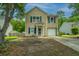 Inviting two-story home featuring blue shutters, a front yard, and an attached garage at 5088 Thornton Dr, Summerville, SC 29485
