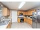 Modern kitchen with wood cabinetry, stainless steel appliances, and tile flooring at 5088 Thornton Dr, Summerville, SC 29485
