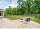 Concrete patio featuring a table and chairs, overlooking a spacious backyard with trees at 5088 Thornton Dr, Summerville, SC 29485