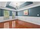 Elegant dining room with tray ceiling, wainscoting, hardwood floors, and a modern chandelier at 5258 Mulholland Dr, Summerville, SC 29485
