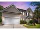 Beautiful two-story home featuring an attached garage, complemented by manicured landscaping and inviting exterior lighting at 5258 Mulholland Dr, Summerville, SC 29485