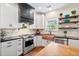 Updated kitchen features open shelving, stainless appliances, a copper sink, and white cabinets with black countertops at 5258 Mulholland Dr, Summerville, SC 29485