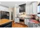 A close-up of the kitchen shows stainless steel appliances, white cabinetry, black countertops and hardwood floors at 5258 Mulholland Dr, Summerville, SC 29485