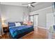 Bright main bedroom features hardwood floors, a ceiling fan, and a sliding barn door to the main bathroom at 5258 Mulholland Dr, Summerville, SC 29485