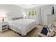 Cozy bedroom with white walls, nautical decor, a bed, and a window overlooking greenery at 55 Fairway Dunes Ln, Isle of Palms, SC 29451
