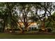Charming two-story home with a welcoming front porch, mature trees, and lush landscaping at 554 Parrot Point Dr, Charleston, SC 29412