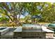 Outdoor kitchen with a built-in grill and sink overlooking a large backyard with marsh views at 554 Parrot Point Dr, Charleston, SC 29412