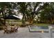 Inviting pool and patio area with outdoor seating, mature trees, and water views create a relaxing backyard oasis at 554 Parrot Point Dr, Charleston, SC 29412