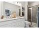 Modern bathroom featuring a double vanity, large mirror, decorative vases, and glass enclosed shower at 566 Scholar Way, Summerville, SC 29486