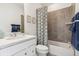 Well-lit bathroom featuring tiled shower, framed art, patterned shower curtain and modern vanity with stone countertop at 566 Scholar Way, Summerville, SC 29486