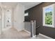Bright hallway with view of a bedroom, features carpeted floor and painted accent wall with staircase and window at 566 Scholar Way, Summerville, SC 29486