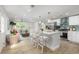 Bright open-concept kitchen features white cabinets, stainless steel appliances, and an island with seating at 6146 Chisolm Rd, Johns Island, SC 29455