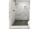 Walk-in shower featuring marble tile walls, a rain shower head, and a dark tiled floor at 6146 Chisolm Rd, Johns Island, SC 29455