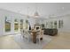 Bright dining area with a rustic table, modern lighting, and large windows to the backyard at 755 Adluh St, Mount Pleasant, SC 29464
