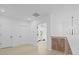 This bright hallway has hardwood floors, white walls, and doorways leading to other rooms with a stylish chandelier at 755 Adluh St, Mount Pleasant, SC 29464